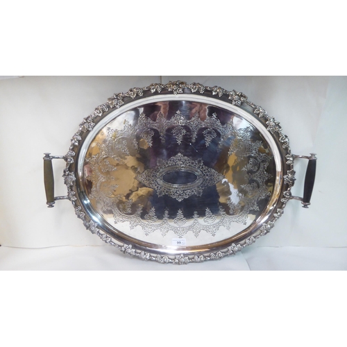 99 - Metalware: to include a late Victorian silver plated tray with opposing handles and a cast fruiting ... 