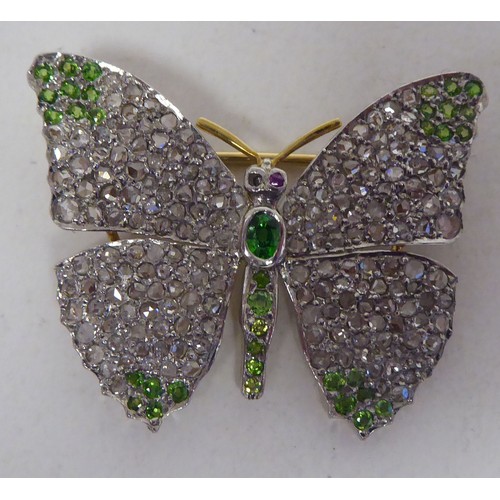 115 - A bi-coloured gold, diamond encrusted and coloured stone set brooch, fashioned as a butterfly