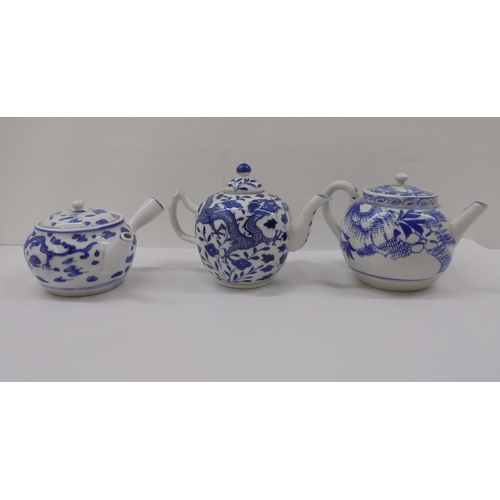 128 - Three Chinese porcelain teapots of similar form, decorated in blue and white