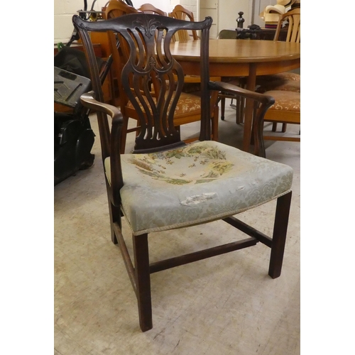 35 - An early 19thC Chippendale inspired mahogany framed elbow chair with a yoke back and a waisted, pier... 