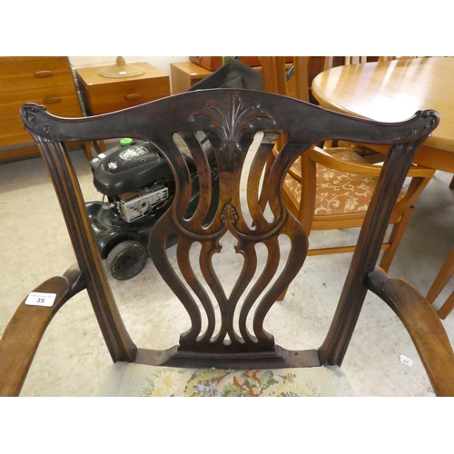35 - An early 19thC Chippendale inspired mahogany framed elbow chair with a yoke back and a waisted, pier... 