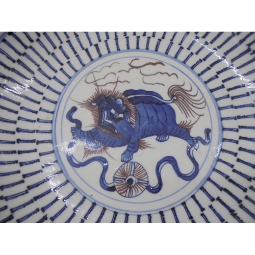 40 - A 19thC Chinese provincial footed porcelain dish, decorated in blue, brown and white with a dragon-d... 