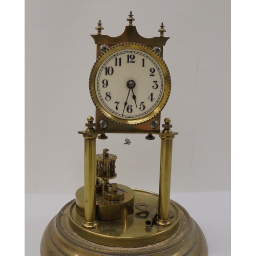 55 - A German made, lacquered brass cased torsion timepiece, the exposed movement on twin pillars, faced ... 
