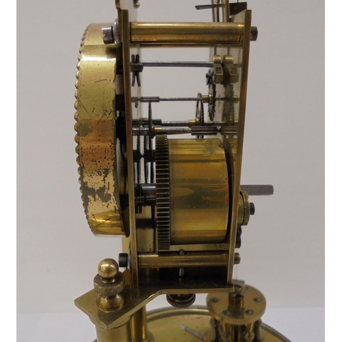 55 - A German made, lacquered brass cased torsion timepiece, the exposed movement on twin pillars, faced ... 