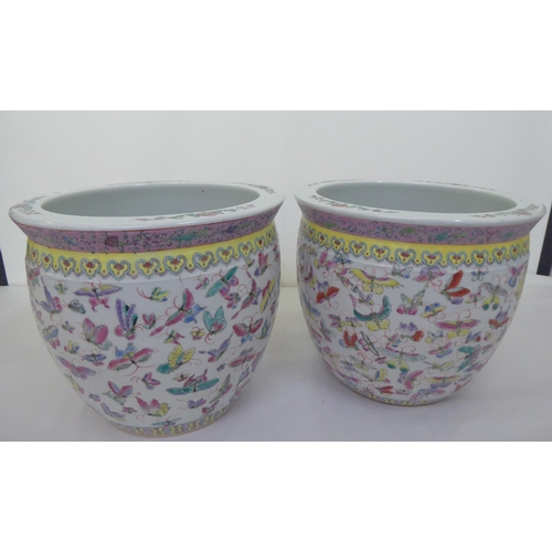 102 - A pair of modern Chinese design china jardinières of bulbous form, decorated in colours with ... 