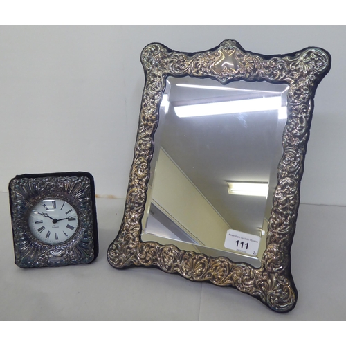 111 - A Victorian style dressing table mirror, the bevelled plate set in an overlaid and embossed silver f... 