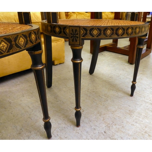 121 - A pair of early 19thC style black painted and gilded beech framed chairs, each having a curved crest... 