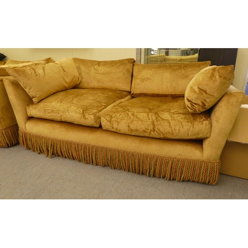 123 - A modern box settee with a low back and enclosed arms, upholstered in tasselled old gold coloured fa... 