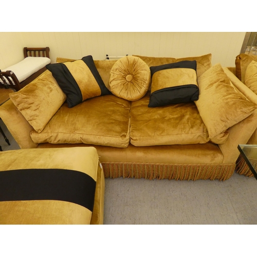 124 - A modern box settee with a low back and enclosed arms, upholstered in tasselled old gold coloured fa... 