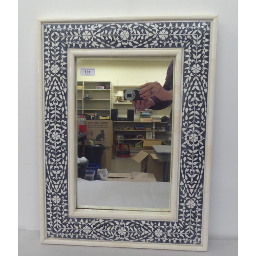 131 - A modern Middle Eastern mirror, set in a black and white ornamented frame  24