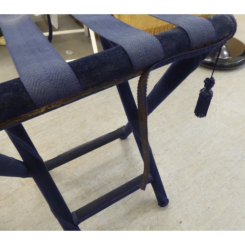 139 - A pair of luggage stands, respectively finished in navy blue and pillar box red fabric, raised on ta... 