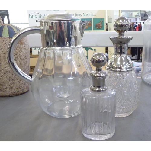 148 - Glass tableware: to include two cordial jugs with applied metal mounts 