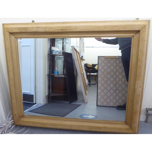 168 - A waxed pine mirror, set in a wide, moulded frame  45