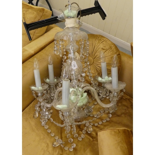 170 - A 20thC copy of an earlier French clear glass chandelier with five scrolled branches, pendants and t... 