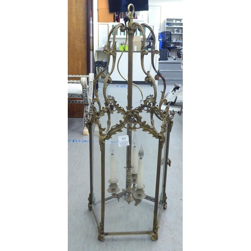 177 - A 19thC style, scrolled gilded metal framed, glazed hexagonal pendant lantern, comprising three cand... 