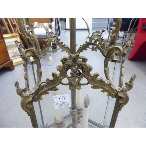 177 - A 19thC style, scrolled gilded metal framed, glazed hexagonal pendant lantern, comprising three cand... 