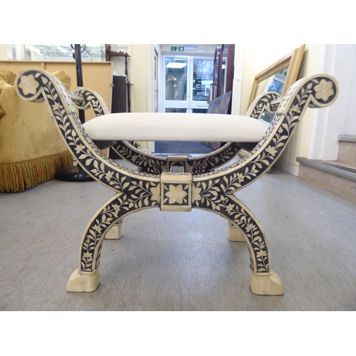 179 - A modern Middle Eastern inspired Savonarola style stool, decorated in black and white with floral de... 