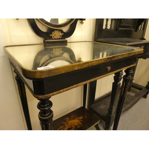 182 - A 19thC style black lacquered dressing table with gilt metal mounts, comprising an oval pivoting mir... 