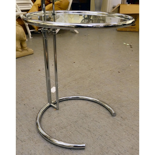 191 - A modern tubular stainless steel framed side table with a height adjustable, clear glass plate glass... 