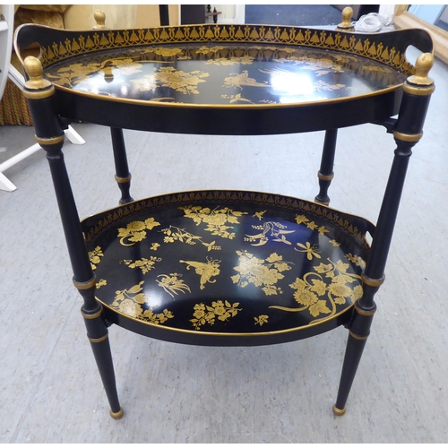 194 - A Regency style black painted and gilded oval tray table and undertier, on a foldable stand  19... 