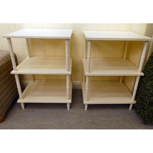 198 - A pair of modern white painted three tier side tables, raised on simulated bamboo uprights  25