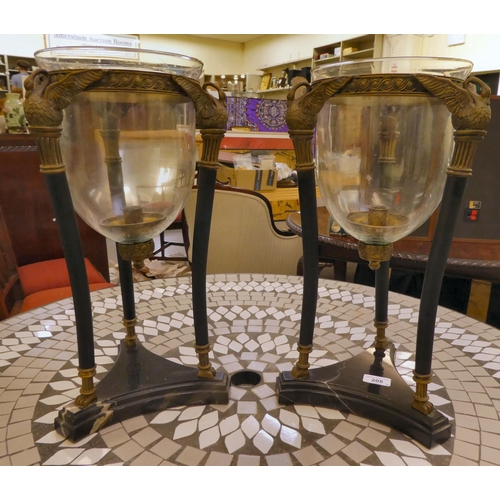 208 - A pair of black painted steel and brass vase stands, in neo-classical taste with clear glass liners,... 