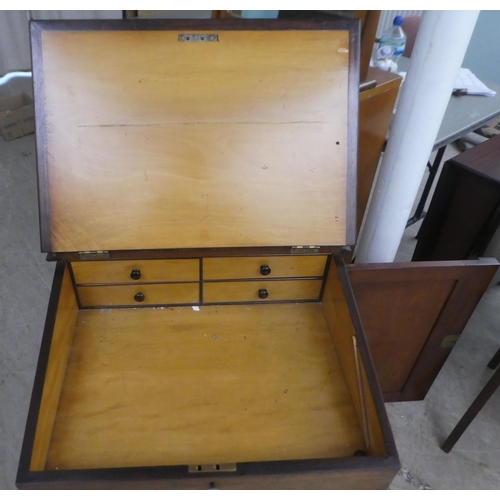 23 - A late Victorian rosewood Davenport with a hinged top and a panelled flank cupboard, on a plinth and... 