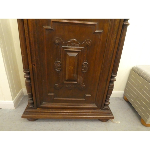 246 - A late 19thC Continental oak cabinet with a drawer and panelled door, raised on bun feet  43