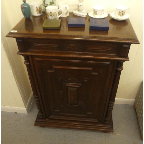 246 - A late 19thC Continental oak cabinet with a drawer and panelled door, raised on bun feet  43