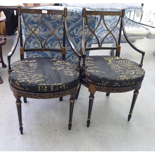 248 - A pair of modern Regency design black and gold painted chairs with a crossover backs, raised on turn... 