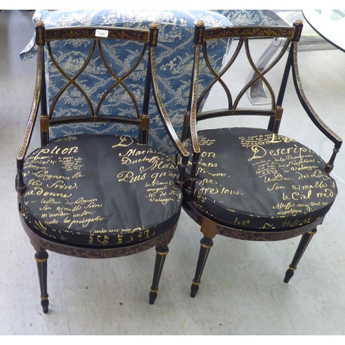 248 - A pair of modern Regency design black and gold painted chairs with a crossover backs, raised on turn... 