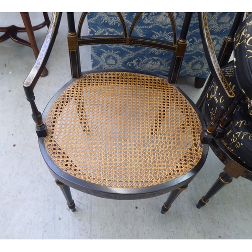 248 - A pair of modern Regency design black and gold painted chairs with a crossover backs, raised on turn... 