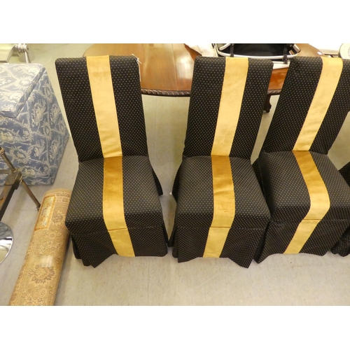 253 - A set of six black and gold fabric covered dining chairs, raised on stained beech legs 