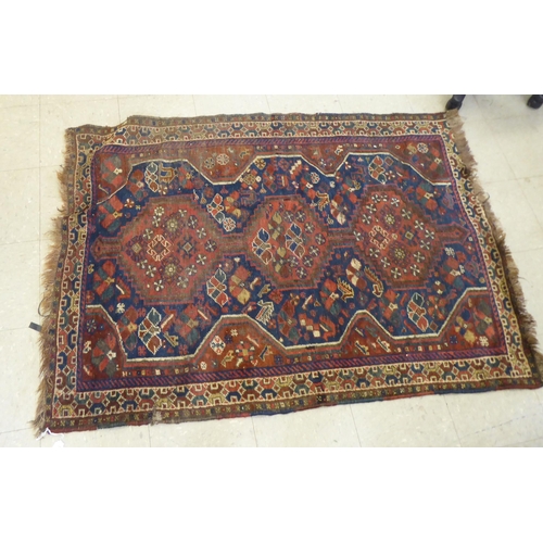 263 - A Persian rug, decorated with triple gul motifs, on a red and blue ground  45