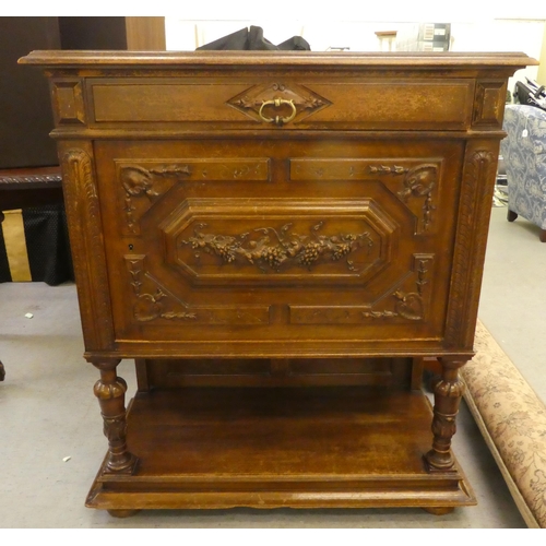 264 - A late 19thC Continental oak cabinet with a drawer and a carved panelled door, raised on turned legs... 