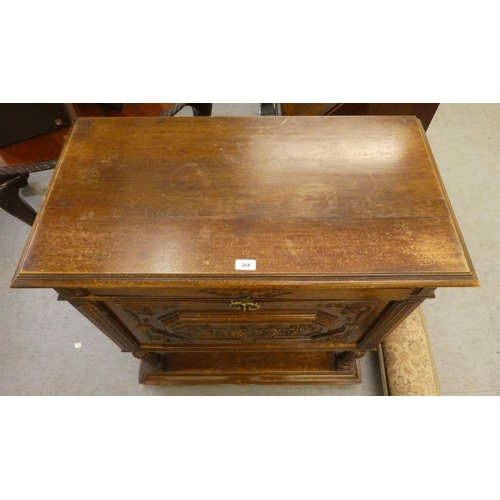 264 - A late 19thC Continental oak cabinet with a drawer and a carved panelled door, raised on turned legs... 