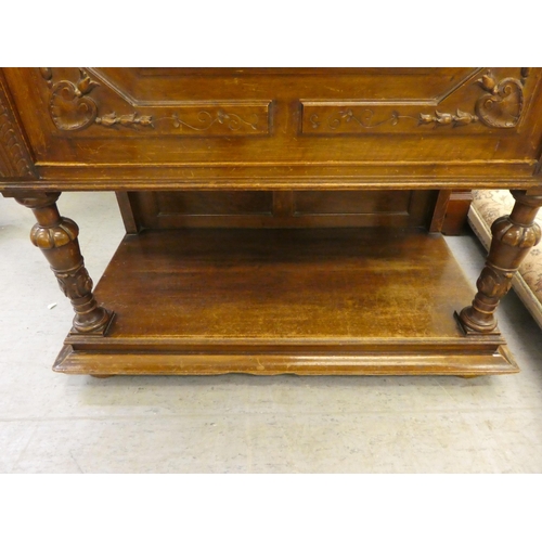 264 - A late 19thC Continental oak cabinet with a drawer and a carved panelled door, raised on turned legs... 