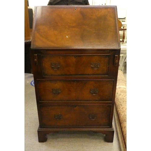 265 - A modern mahogany finished bureau with a fall flap, over three drawers, raised on bracket feet  46