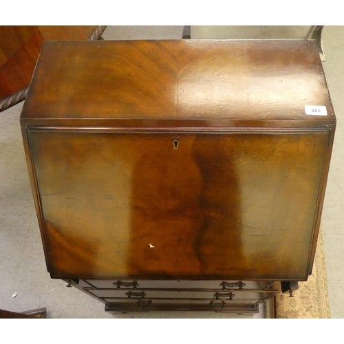 265 - A modern mahogany finished bureau with a fall flap, over three drawers, raised on bracket feet  46