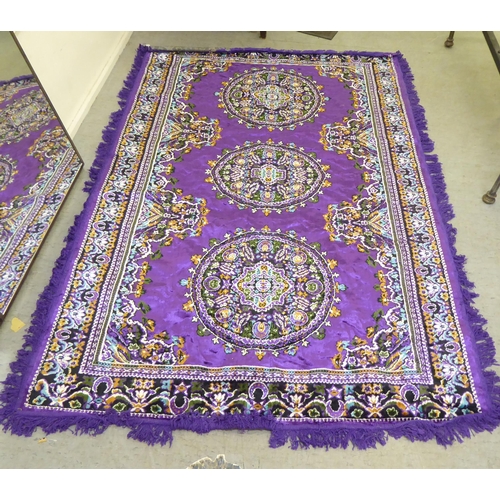 266 - A Persian design rug, decorated with floral motifs, on a purple ground  86