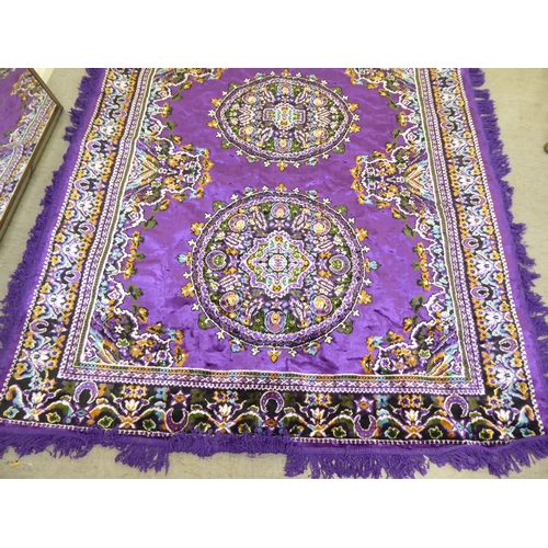 266 - A Persian design rug, decorated with floral motifs, on a purple ground  86