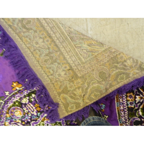 266 - A Persian design rug, decorated with floral motifs, on a purple ground  86