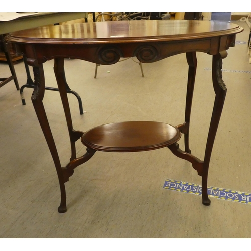 276 - An early 20thC mahogany, oval, two tier occasional table, raised on slender legs and pad feet  ... 