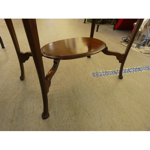 276 - An early 20thC mahogany, oval, two tier occasional table, raised on slender legs and pad feet  ... 