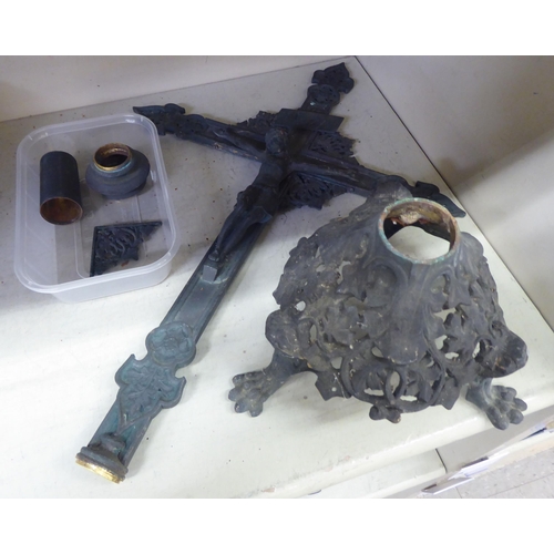 87 - A Continental blackened metal crucifix with decoratively pierced ornament, on a triform stand  ... 