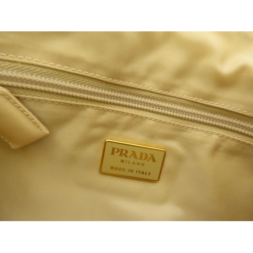 90 - Three Prada fabric handbags, viz. a Raso Gold 1998 with dust cover, one in cream coloured net with p... 