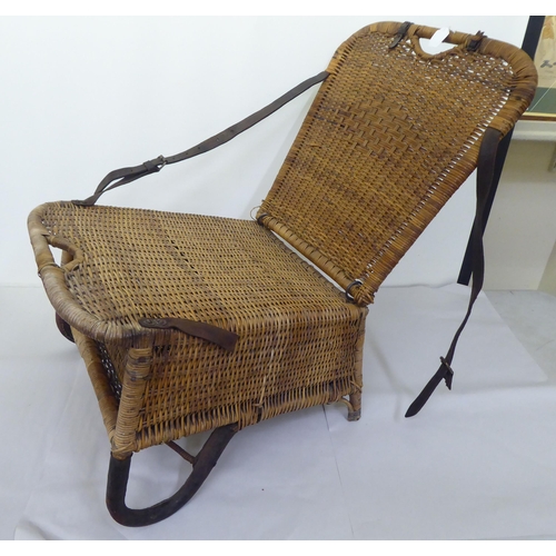 97 - A late Victorian/Edwardian woven split cane folding campaign/anglers chair with a storage compartmen... 