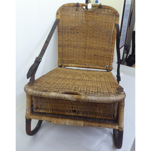 97 - A late Victorian/Edwardian woven split cane folding campaign/anglers chair with a storage compartmen... 