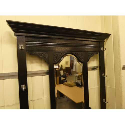 99 - A late Victorian black stained and carved oak hallstand, incorporating a bevelled mirror and an offs... 