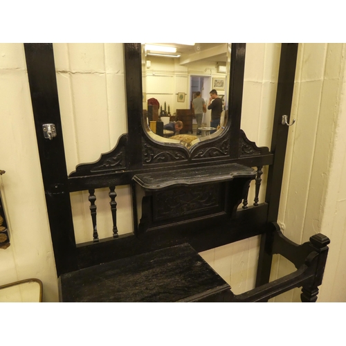 99 - A late Victorian black stained and carved oak hallstand, incorporating a bevelled mirror and an offs... 